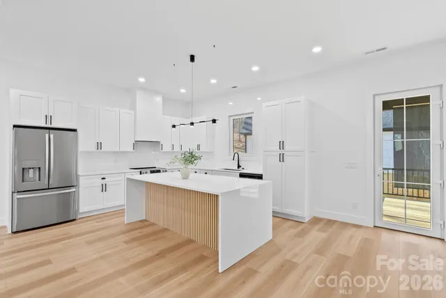 a kitchen with white cabinets and stainless steel appliances