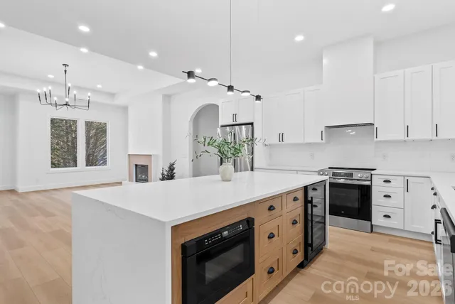 a kitchen with stainless steel appliances sink stove and cabinets