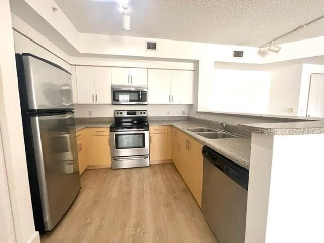 7930 North Nob Hill Road, Unit 106 Tamarac, FL 33321 - Photo 5 of 12 a kitchen with stainless steel appliances granite countertop a stove a sink and a refrigerator