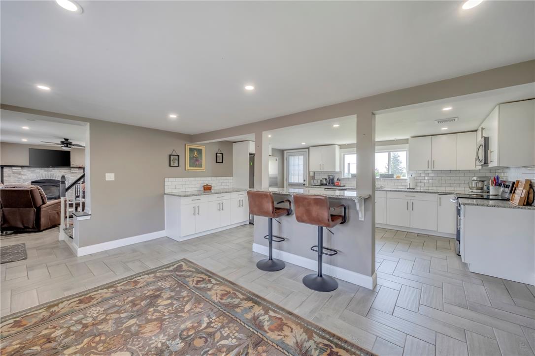 439 Cherry Hill Road Nazareth, PA 18064 - Photo 24 of 31 Herringbone-patterned floors flow through this open-concept kitchen and living area, complete with a breakfast bar.