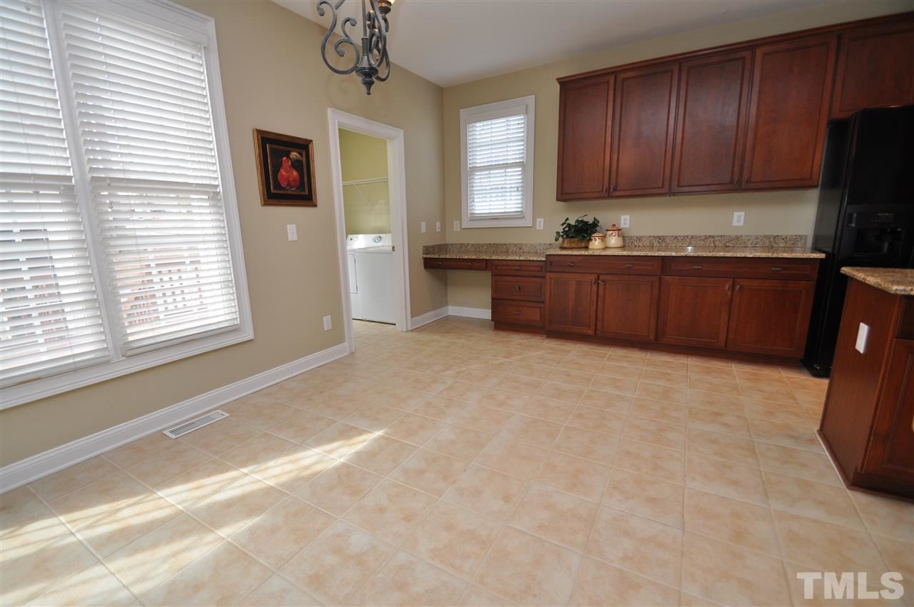 165 Fort Jackson Road Morrisville, NC 27560 - Photo 11 of 25 a kitchen with granite countertop a refrigerator and a stove top oven