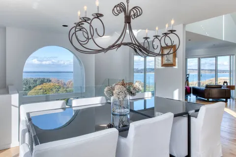 a living room with furniture a chandelier and a large window