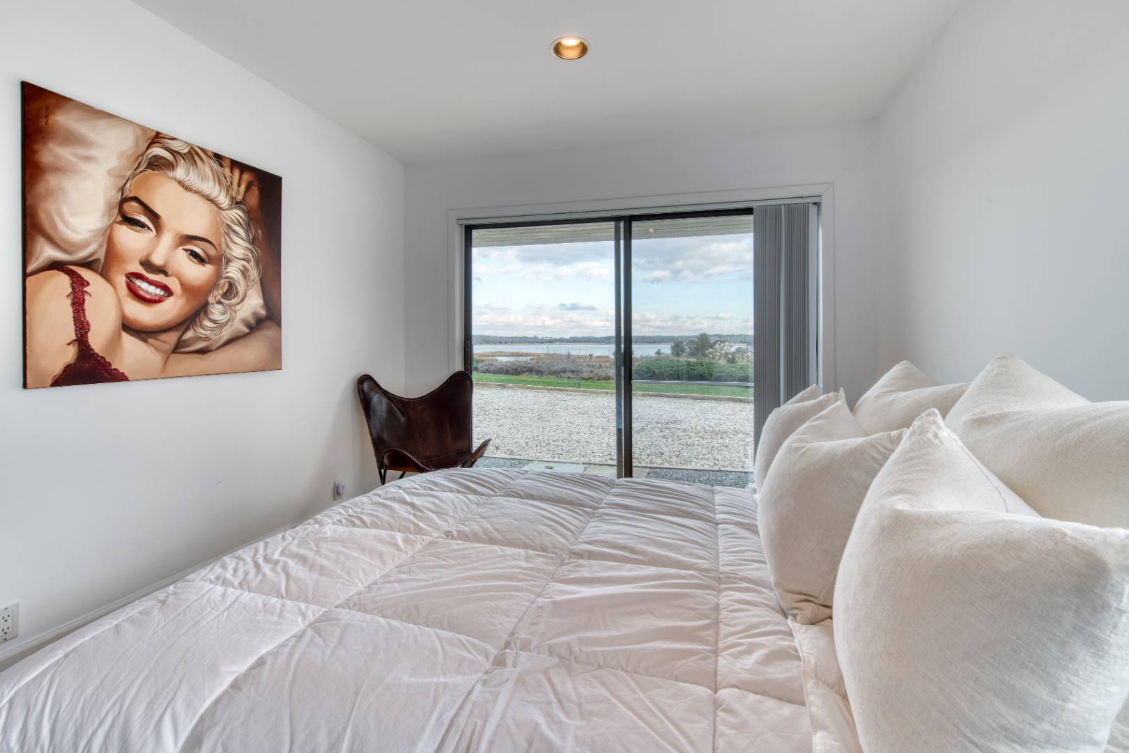 84 Inlet Road East Southampton, NY 11968 - Photo 7 of 13 a large bed sitting in a bedroom next to a window