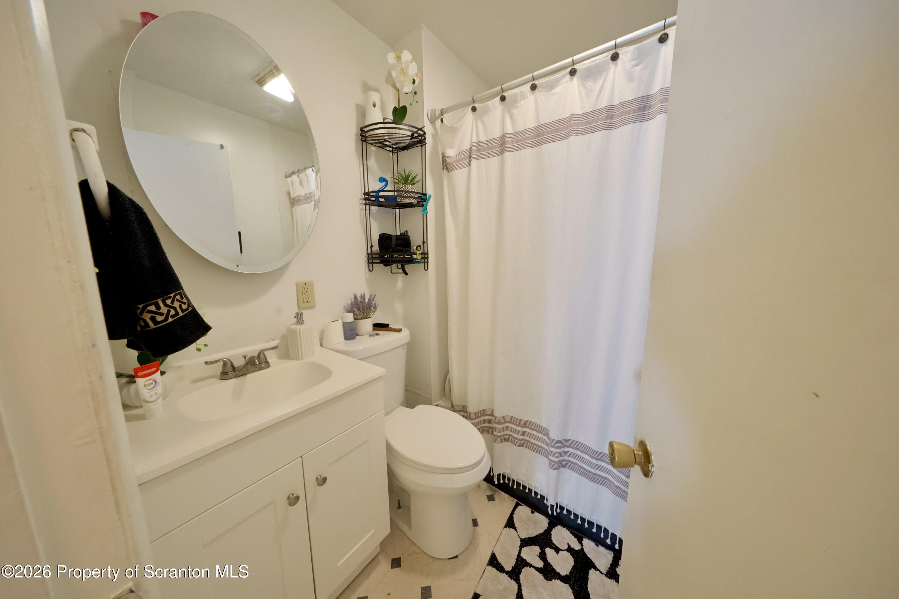 1016-1018 Diamond Avenue Scranton, PA 18508 - Photo 6 of 15 a bathroom with a sink a toilet and shower curtain