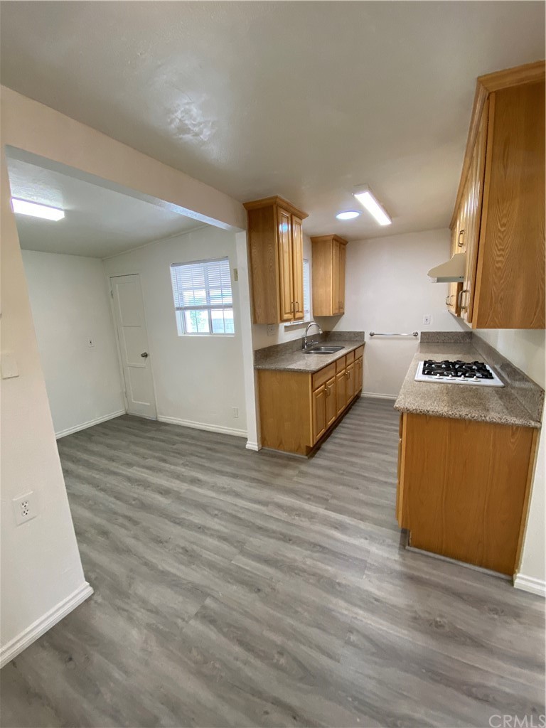 2554 Potrero Avenue El Monte, CA 91733 - Photo 9 of 22 a kitchen with stainless steel appliances granite countertop a sink wooden cabinets and wooden floor