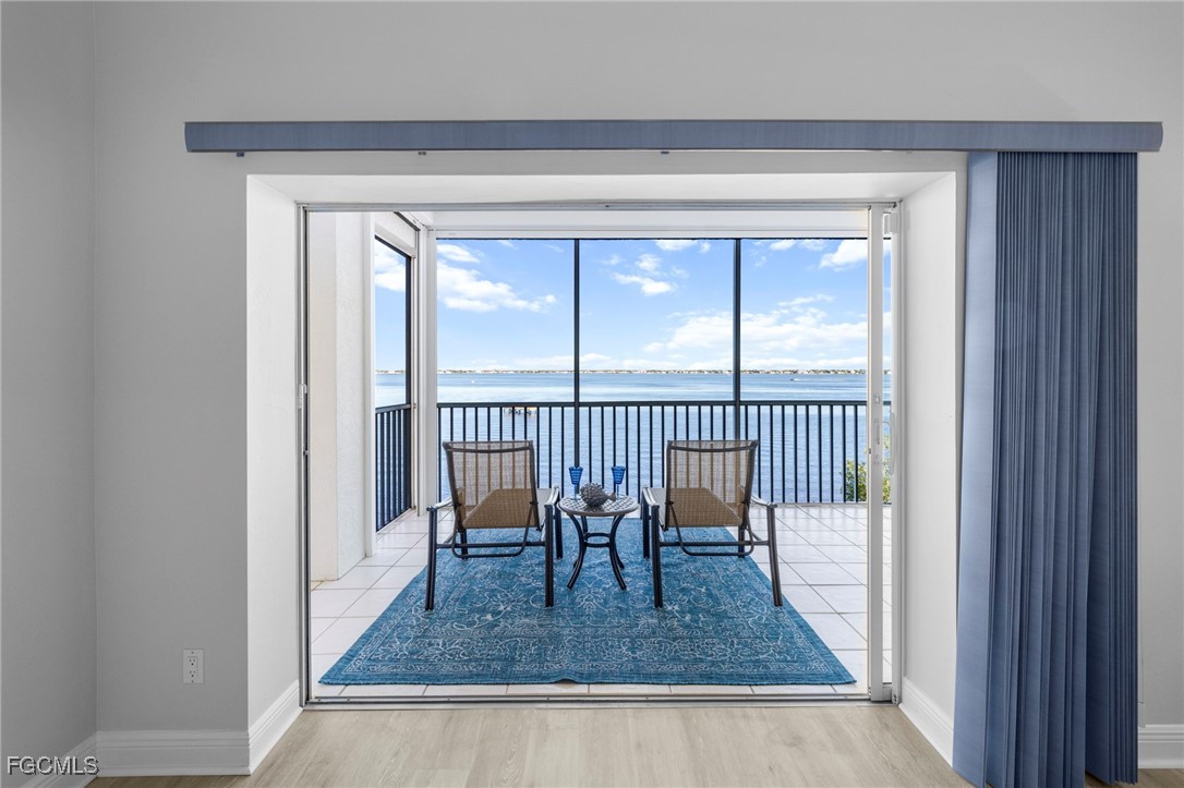 14813 Laguna Drive, Unit 301 Fort Myers, FL 33908 - Photo 32 of 50 a view of a hallway and a dining room with wooden floor