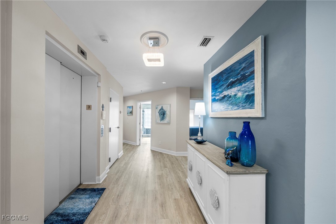 14813 Laguna Drive, Unit 301 Fort Myers, FL 33908 - Photo 37 of 50 a hallway with furniture and wooden floor