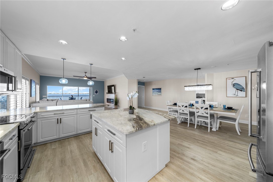 14813 Laguna Drive, Unit 301 Fort Myers, FL 33908 - Photo 7 of 50 a large kitchen with kitchen island a sink table and chairs