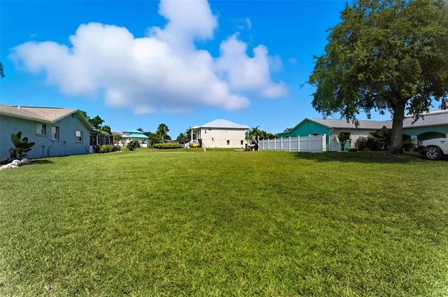 a view of a house with a yard and a large tree