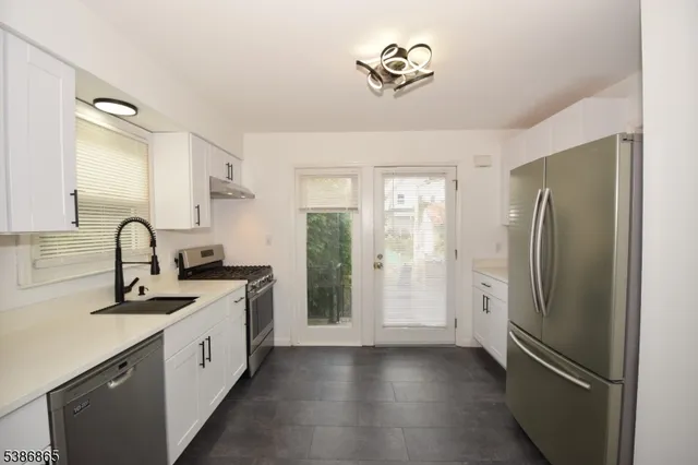 a kitchen with stainless steel appliances granite countertop a refrigerator and a sink