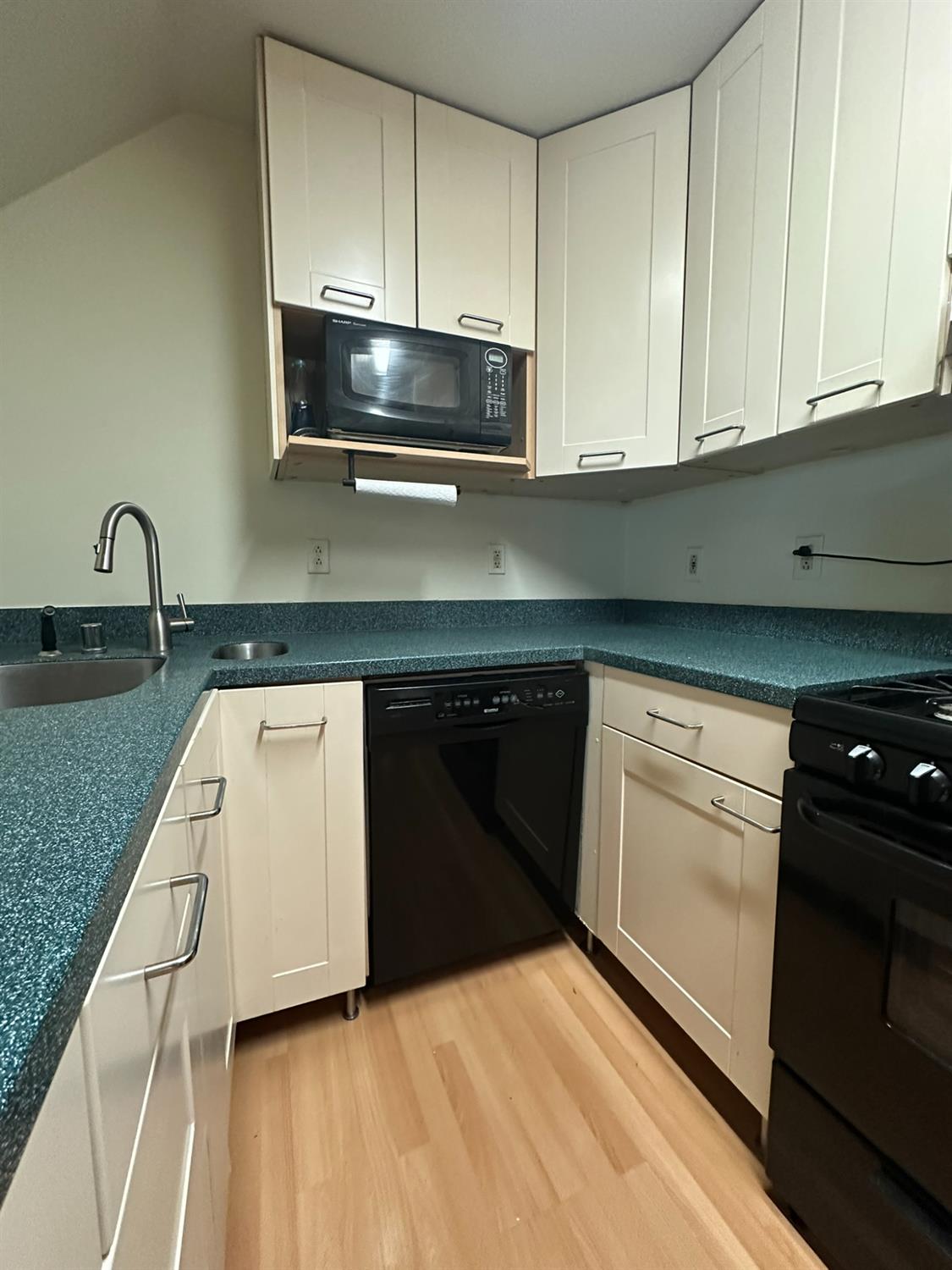 2900 Pole Line Road, Unit 2 Davis, CA 95618 - Photo 11 of 34 a kitchen with granite countertop white cabinets and black appliances