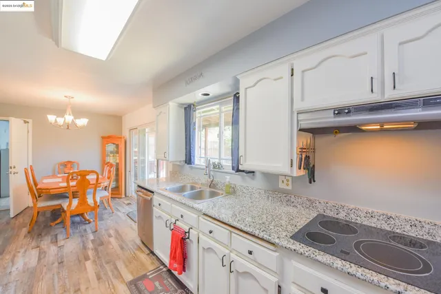 a kitchen with granite countertop a sink a stove and cabinets