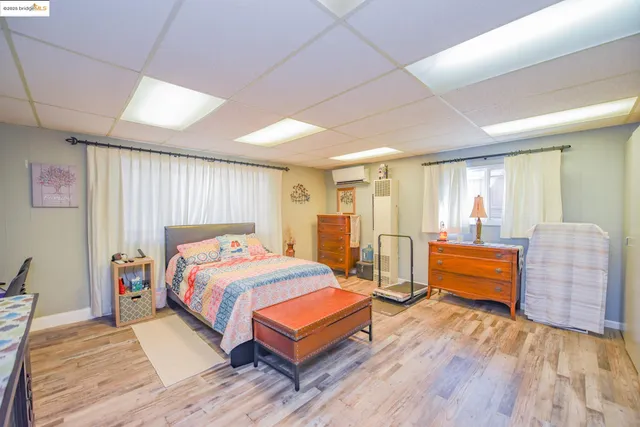 a bedroom with a bed and a flat tv screen on dresser