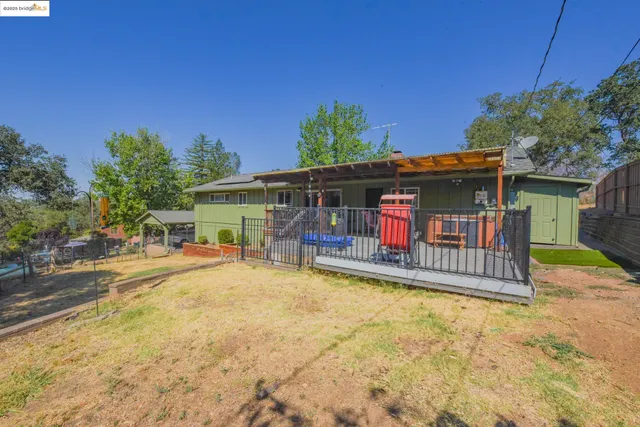a view of a patio with table and chairs potted plants with wooden floor and fence