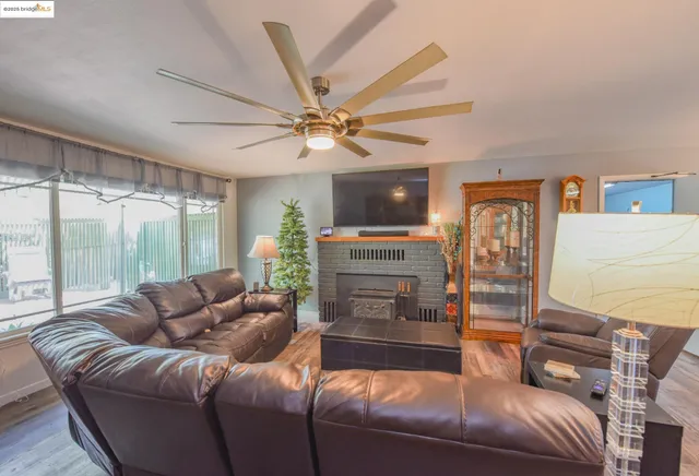 a living room with furniture a ceiling fan and a window