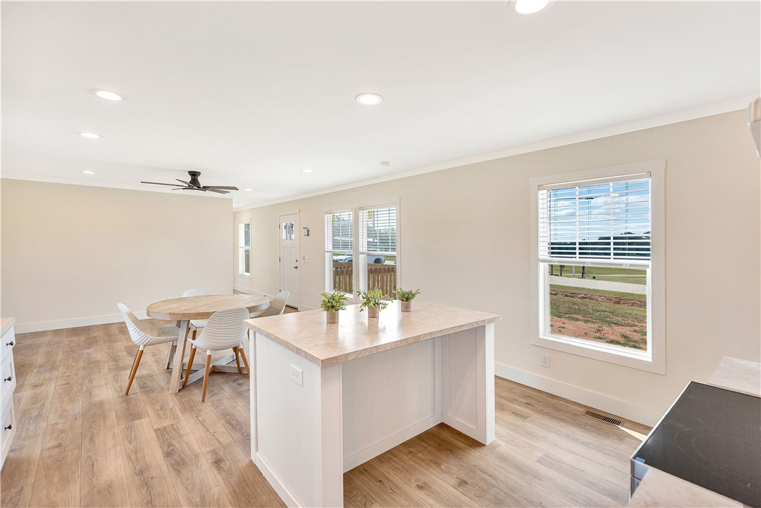 205 Wade Farm Road Fair Play, SC 29643 - Photo 14 of 23 Smooth wood-plank flooring runs beneath high ceilings with recessed lighting in this open-concept layout.