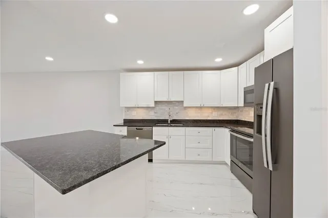 an empty room with chandelier and windows