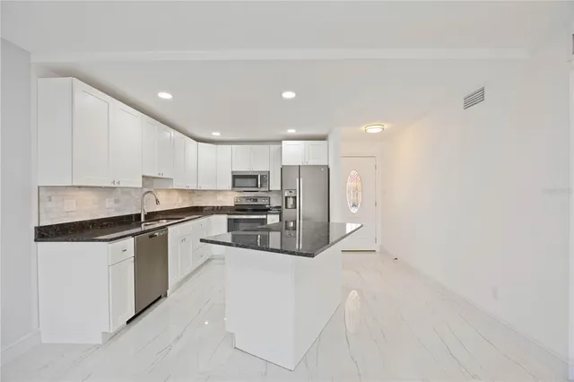 a kitchen with granite countertop a sink and a stove
