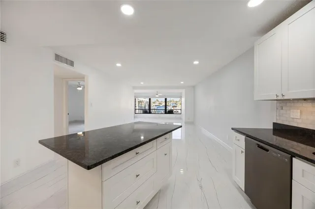 a kitchen with granite countertop white cabinets and white appliances