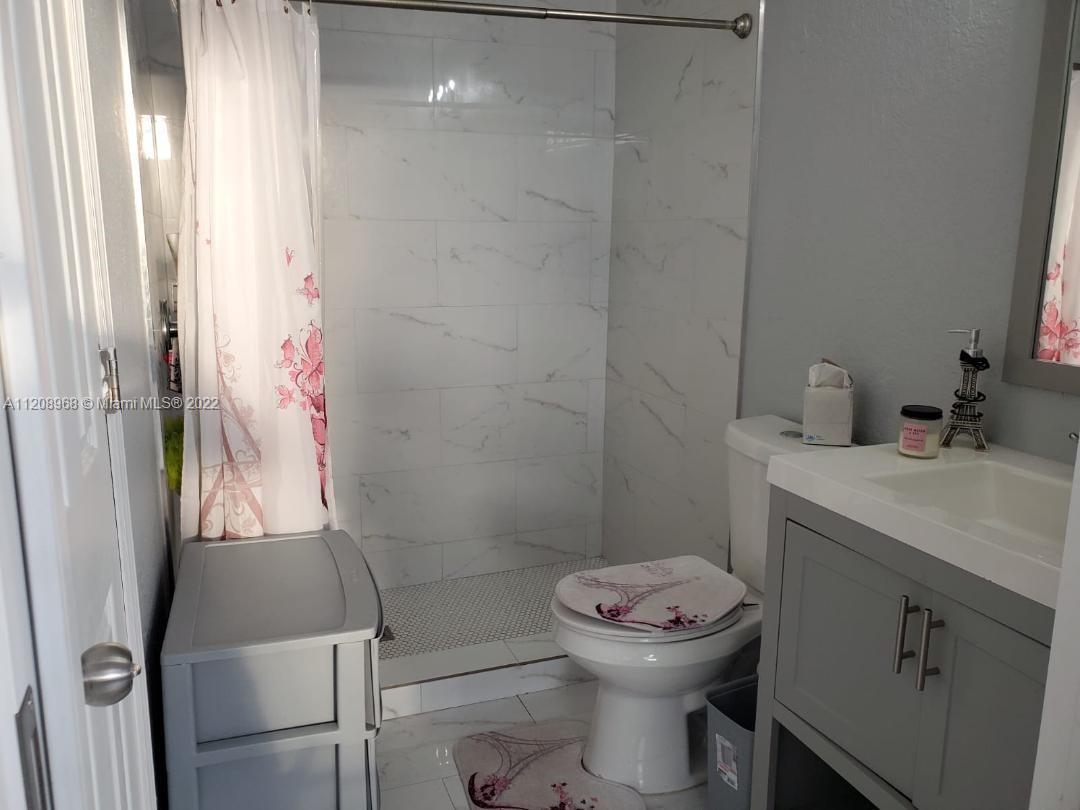 10650 Eland Street Boca Raton, FL 33428 - Photo 12 of 17 a bathroom with a sink a toilet and shower