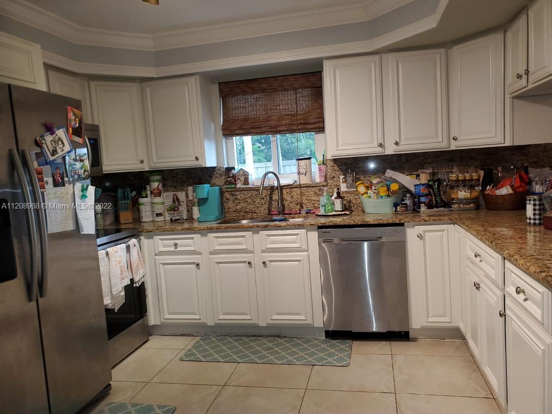 10650 Eland Street Boca Raton, FL 33428 - Photo 5 of 17 a kitchen with white cabinets and white appliances