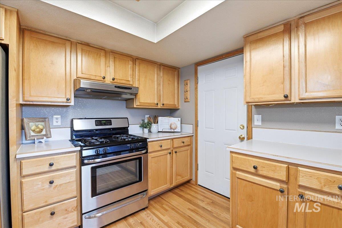 11842 Tioga Street Boise, ID 83709 - Photo 13 of 50 Kitchen featuring wood-finish flooring, light wood cabinetry, white countertops, and a stainless steel oven range