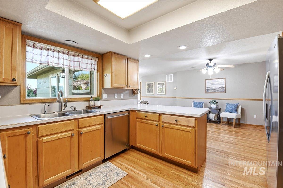 11842 Tioga Street Boise, ID 83709 - Photo 14 of 50 Kitchen featuring light wood cabinetry, light-toned countertops, and stainless steel appliances