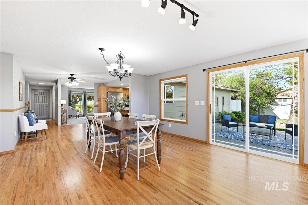 11842 Tioga Street Boise, ID 83709 - Photo 15 of 50 Dining area with wood-finish flooring, a traditional chandelier, and light gray walls