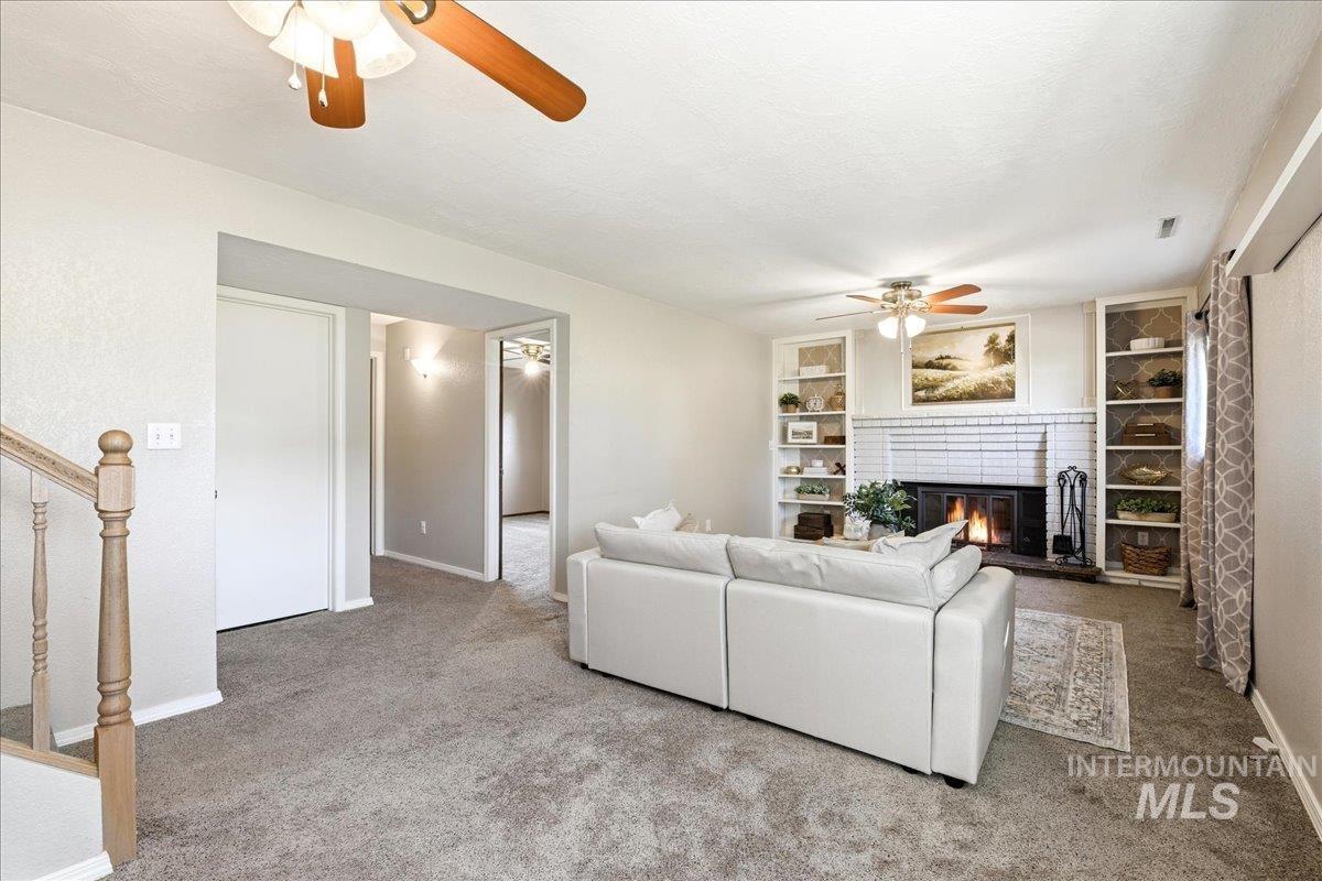 11842 Tioga Street Boise, ID 83709 - Photo 21 of 50 Living area featuring a white brick fireplace with a dark metal firebox, flanked by built-in white shelving