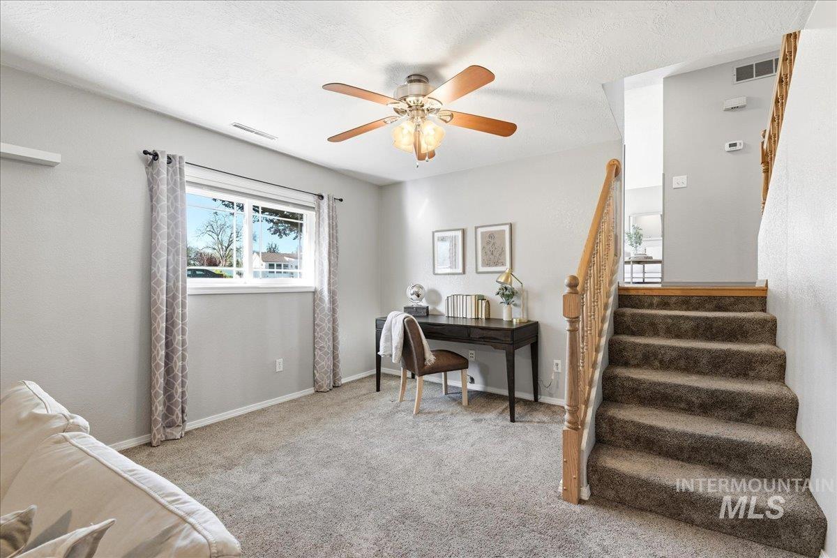 11842 Tioga Street Boise, ID 83709 - Photo 23 of 50 Carpeted room featuring a ceiling fan with integrated lighting, a window with curtains, and a wooden staircase with carpeted treads