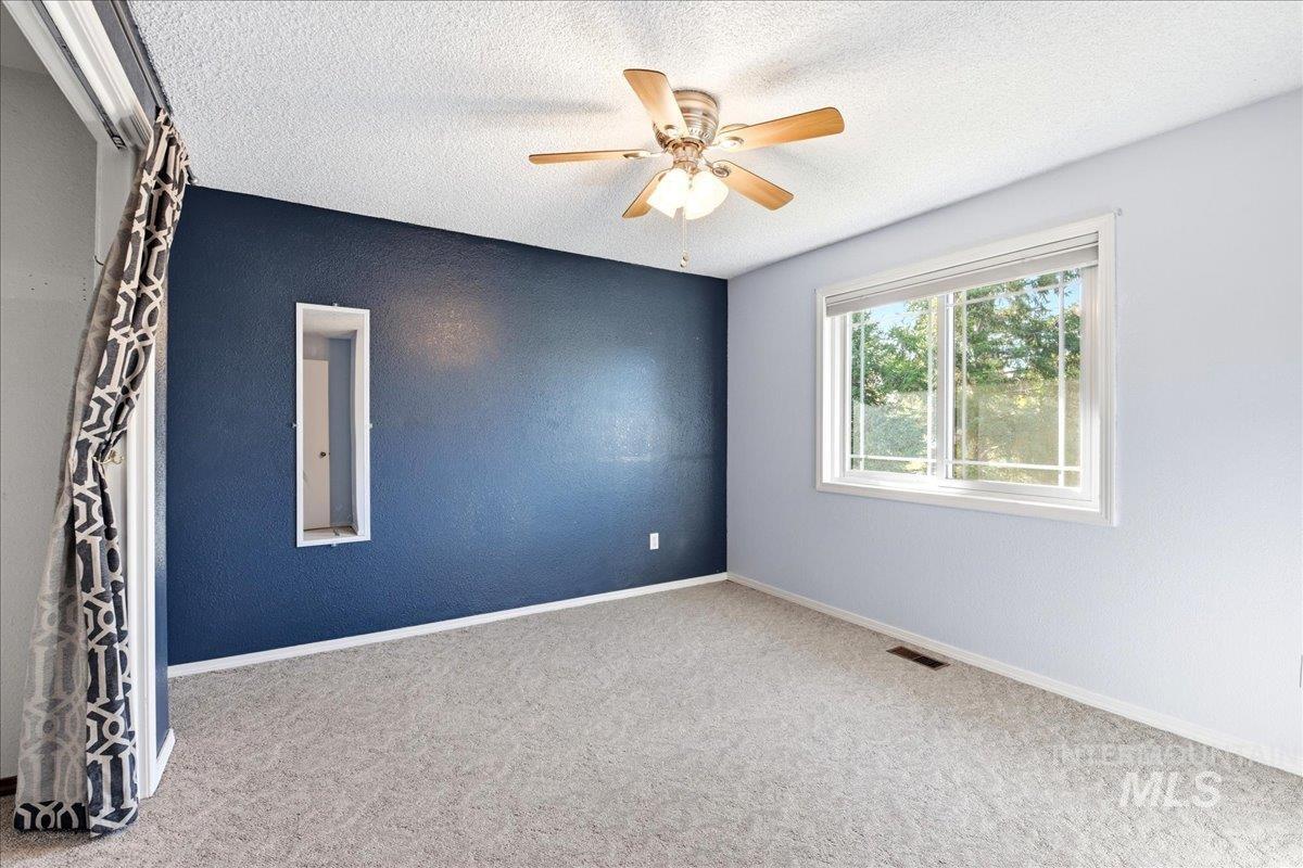 11842 Tioga Street Boise, ID 83709 - Photo 25 of 50 Spacious room featuring light gray carpeting, a ceiling fan with light fixture, and a window with white trim