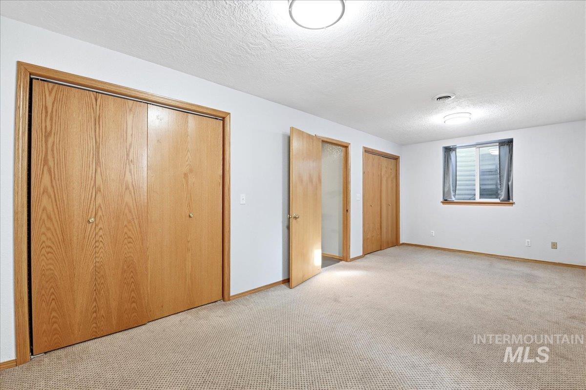 11842 Tioga Street Boise, ID 83709 - Photo 32 of 50 Spacious room featuring neutral carpet flooring, three blonde wood-finish doors, and a window with blinds