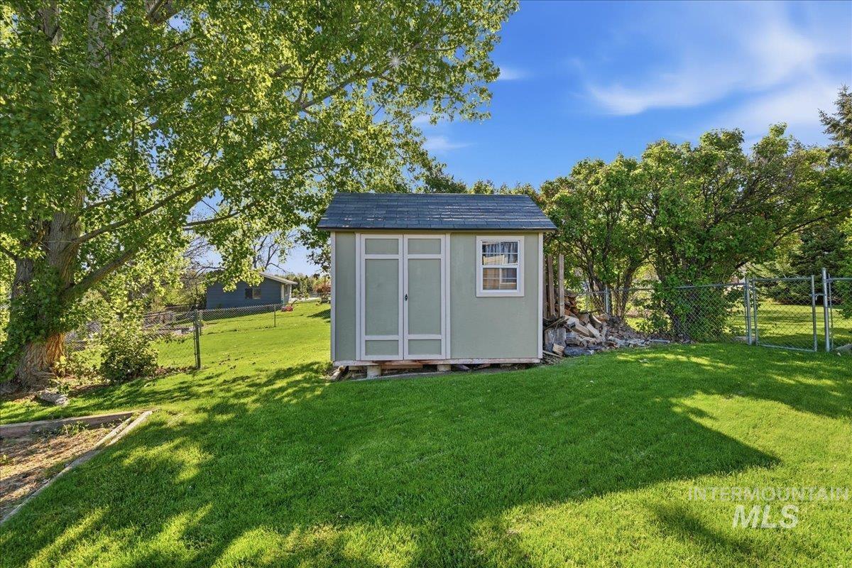 11842 Tioga Street Boise, ID 83709 - Photo 37 of 50 Light green storage shed with white trim, a dark shingle roof, and a single window