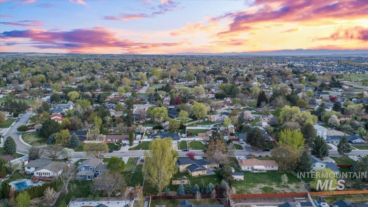 11842 Tioga Street Boise, ID 83709 - Photo 46 of 50 Expansive residential area featuring numerous single-family homes, mature trees, and a distant mountain range under a vibrant sky