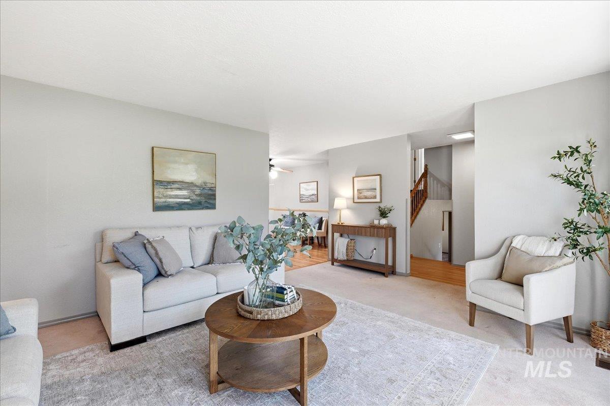 11842 Tioga Street Boise, ID 83709 - Photo 5 of 50 Spacious living area featuring light-toned wall finishes, carpet flooring, and a wood-finish staircase