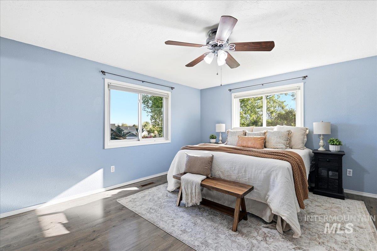 11842 Tioga Street Boise, ID 83709 - Photo 6 of 50 Spacious room featuring two windows, wood-finish flooring, a ceiling fan, and light blue walls