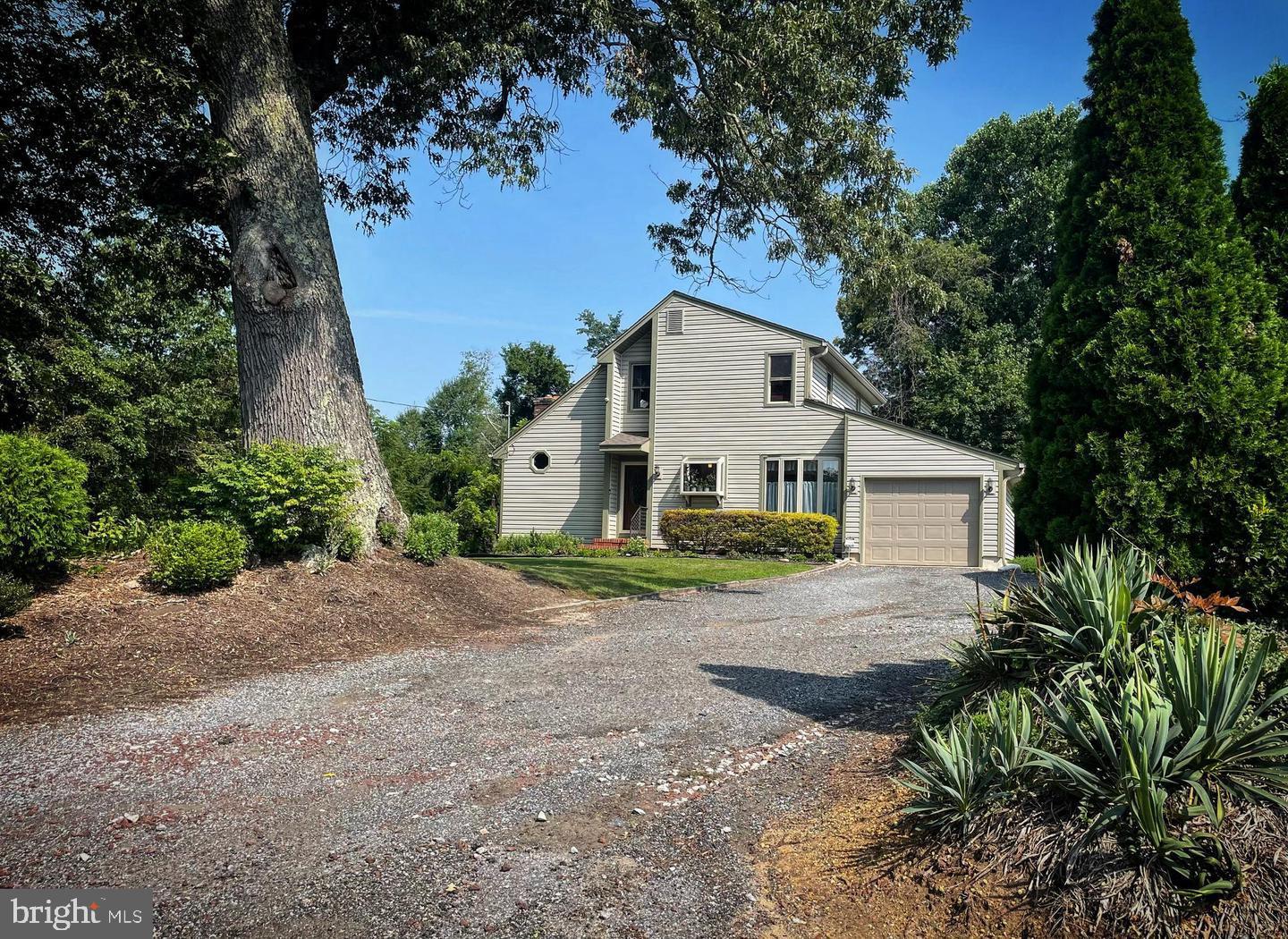 a view of a house with a yard and large tree