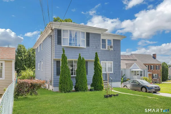 a front view of a house with a garden and plants