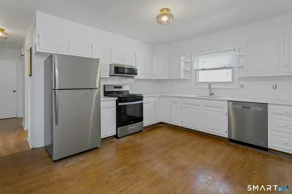 a kitchen with stainless steel appliances a refrigerator sink and microwave