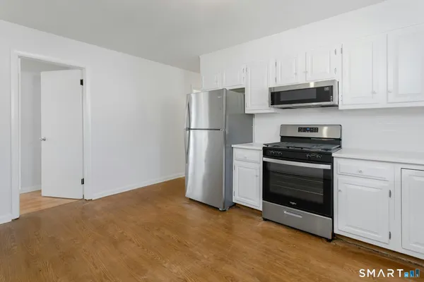 a kitchen with stainless steel appliances white cabinets and a refrigerator