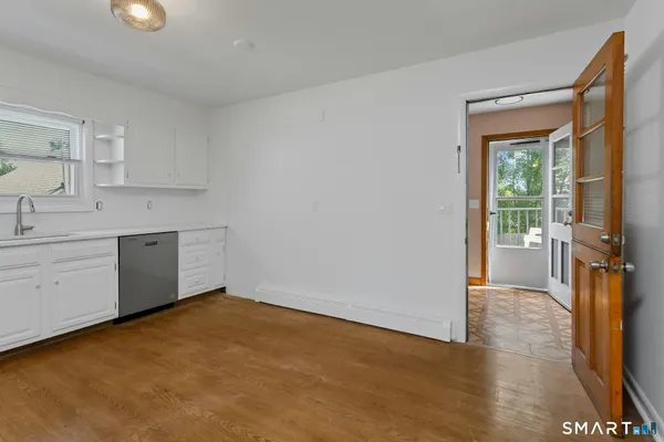 a view of a kitchen with a sink dishwasher and wooden floor