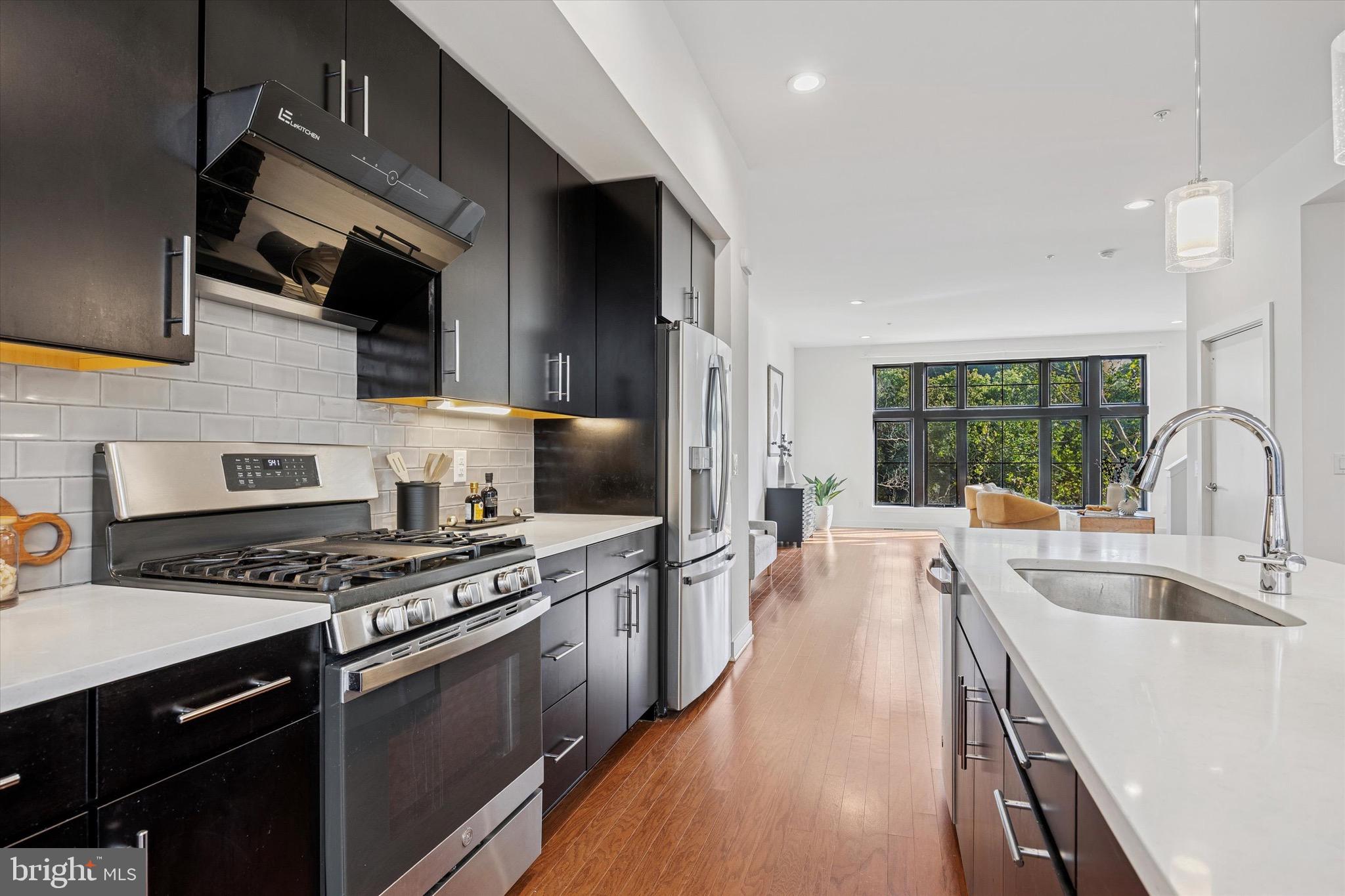 a kitchen with stainless steel appliances a stove sink microwave and cabinets