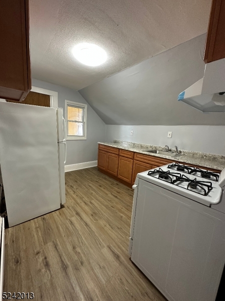 1032 Olive Street, Unit 3 Elizabeth, NJ 07201 - Photo 7 of 9 a kitchen with wooden floors and a stove top oven