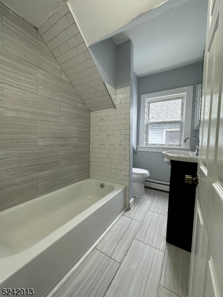 1032 Olive Street, Unit 3 Elizabeth, NJ 07201 - Photo 9 of 9 a bathroom with a bathtub a sink a toilet a vanity and a window