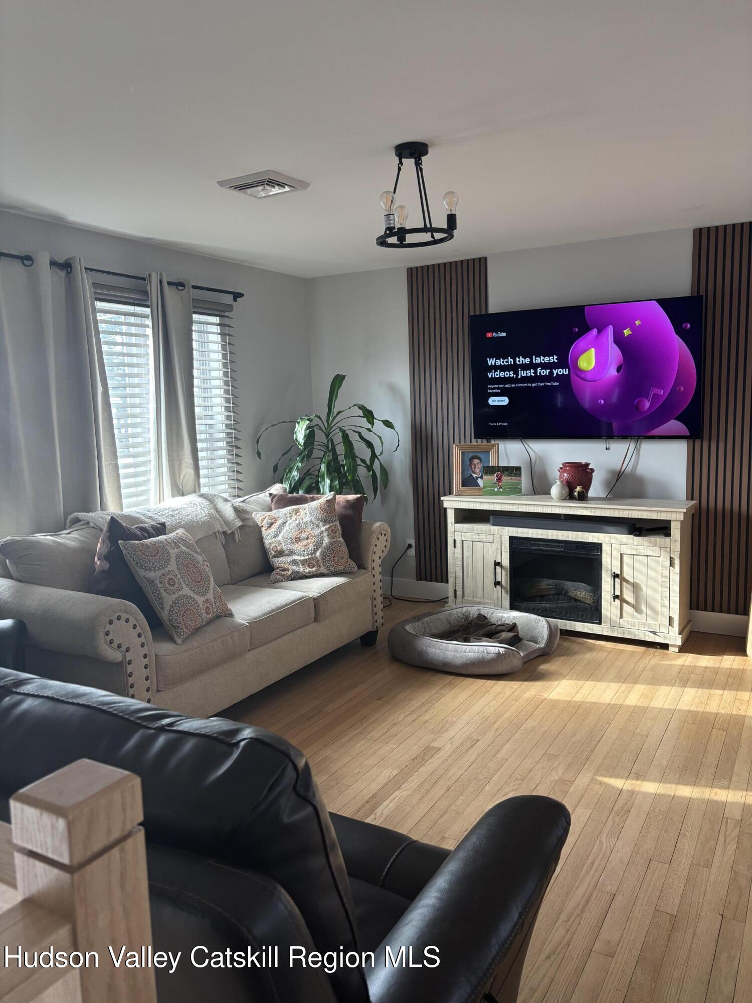 83 Marple Rd Extension Poughkeepsie, NY 12603 - Photo 6 of 23 a living room with furniture a fireplace and a flat screen tv