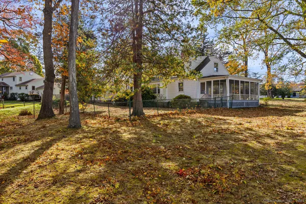 a view of a house with a yard and large tree