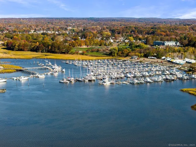 an aerial view of ocean and residential houses with outdoor space