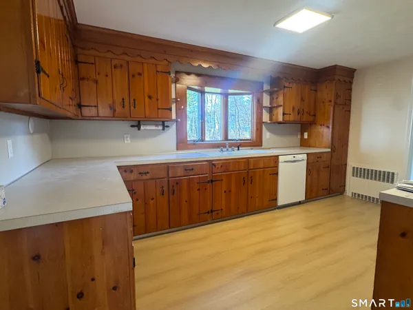 a kitchen with stainless steel appliances granite countertop a sink and cabinets with wooden floor