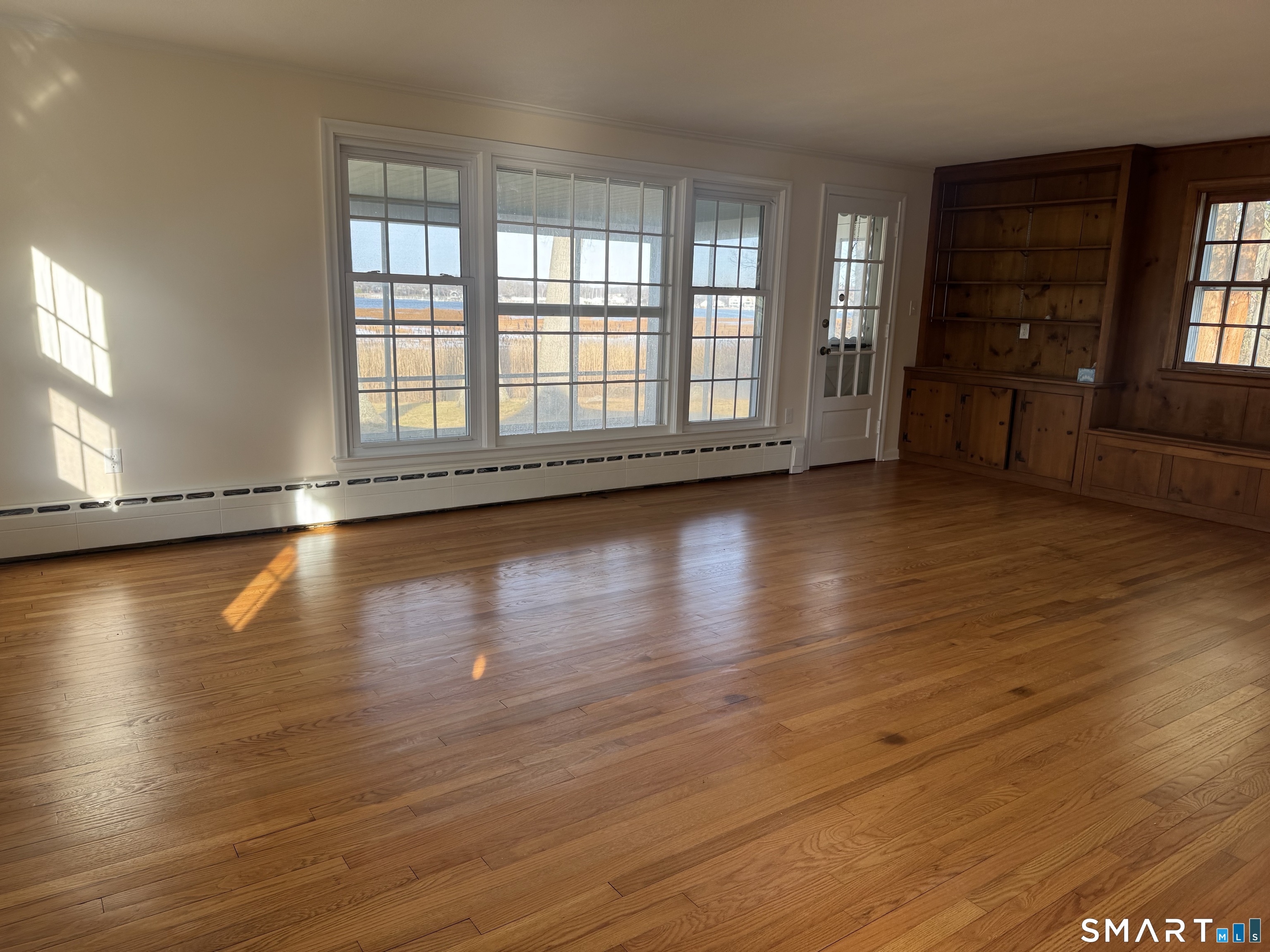 31 Pawson Road Branford, CT 06405 - Photo 9 of 13 an empty room with wooden floor and windows