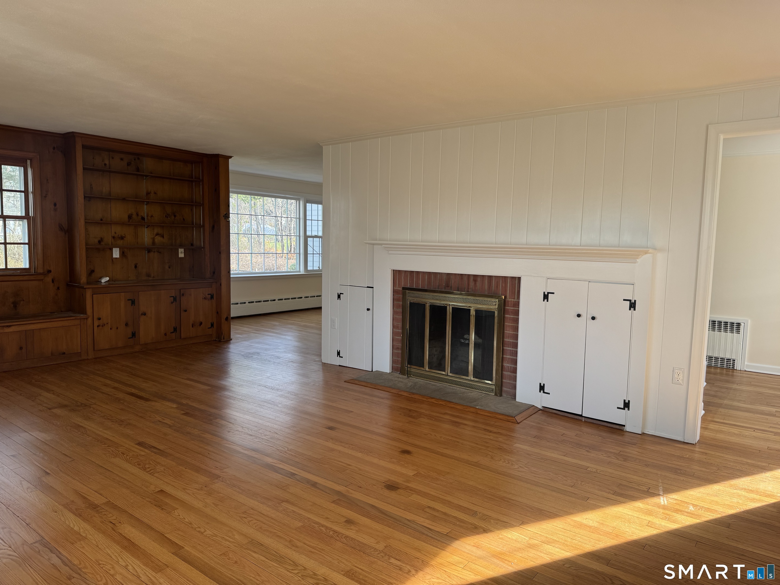 31 Pawson Road Branford, CT 06405 - Photo 10 of 13 an empty room with wooden floor fireplace and windows